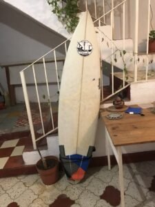 A surfboard resting against a staircase at a house in Manzanillo, Colima.