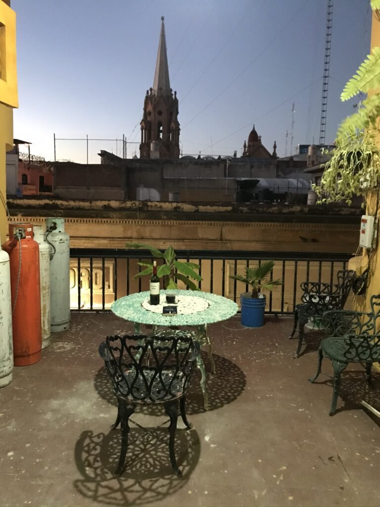 The view from my balcony in León, Guanajuato with a table and chairs at sunset.